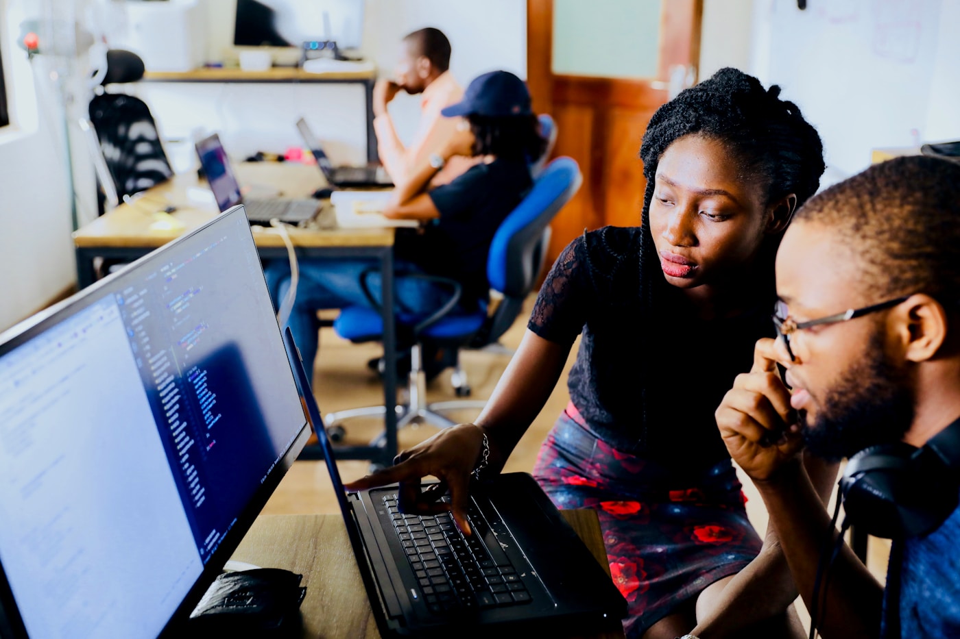 IT specialists reviewing code and troubleshooting together